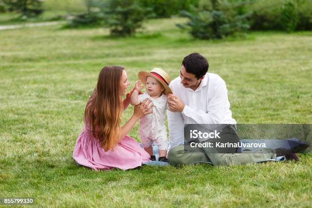Happiness And Harmony Family Life Concept Young Mother And Father With Baby Son In The Park Happy Family Resting Together On The Green Grass Stock Photo - Download Image Now