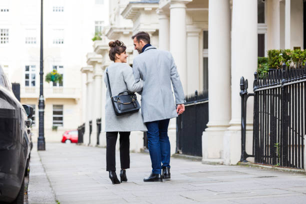 Back view of elegant couple walking in the city street Back view of smart casual romantic couple walking in the city street. Autumn season. victoria house stock pictures, royalty-free photos & images