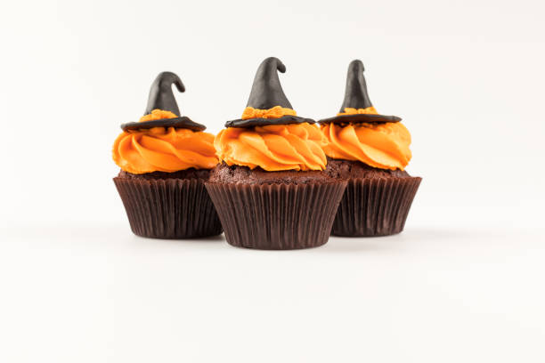 decorative halloween cupcakes close-up view of decorative tasty halloween cupcakes with witch hats isolated on white halloween cupcake stock pictures, royalty-free photos & images