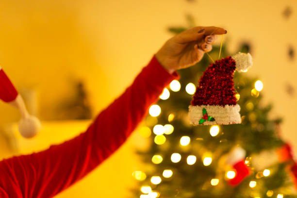 istock Lifting a Christmas hat in front of a defocused tree 855801336