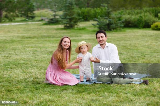 Happiness And Harmony Family Life Concept Young Mother And Father With Baby Son In The Park Happy Family Resting Together On The Green Grass Stock Photo - Download Image Now