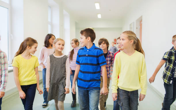 istock group of smiling school kids walking in corridor 855811896
