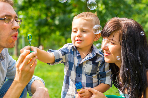 istock Dad holds his son's hand and teaches him to blow soap bubbles. 855812652
