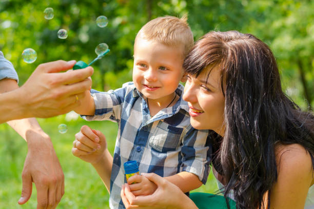 istock Dad holds his son's hand and teaches him to blow soap bubbles. 855814970