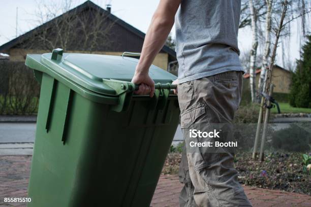 Pushing Garbage Bin Stock Photo - Download Image Now - Garbage Bin, Green Color, Wheeled Garbage Can