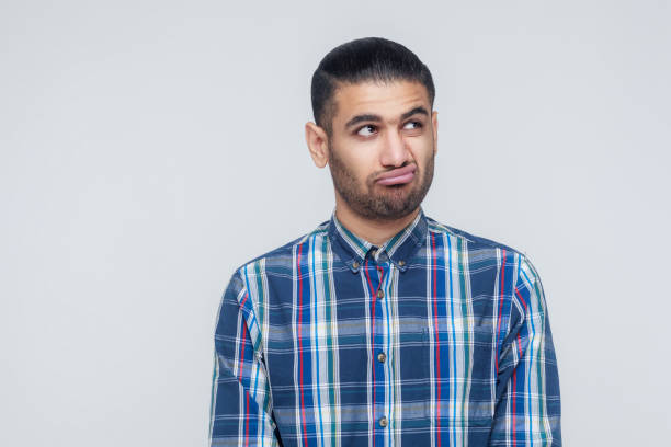 istock Thoughtful bearded businessman looking away while standing against gray wall. 855820376
