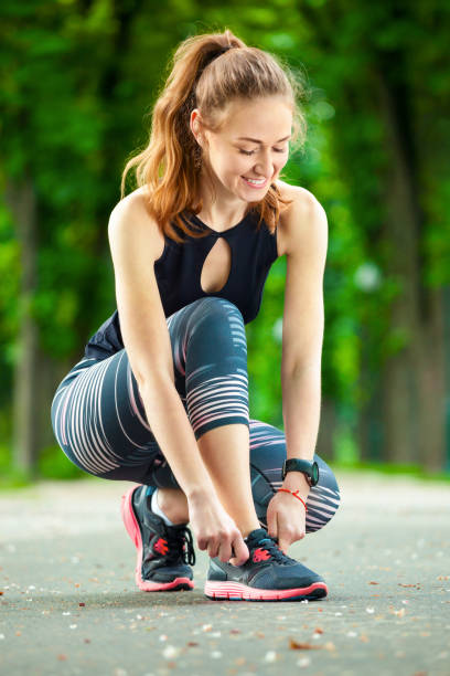 istock Beautiful young woman tying her laces before a run. 855826036