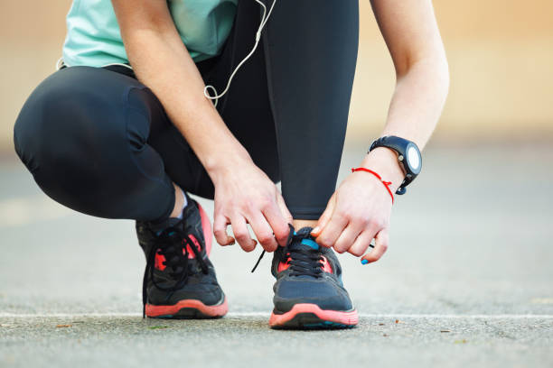 istock Closeup young woman tying her laces before a run. 855826234