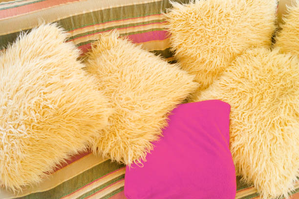 istock Beige and violet artificial wool cushions on the couch 855828630
