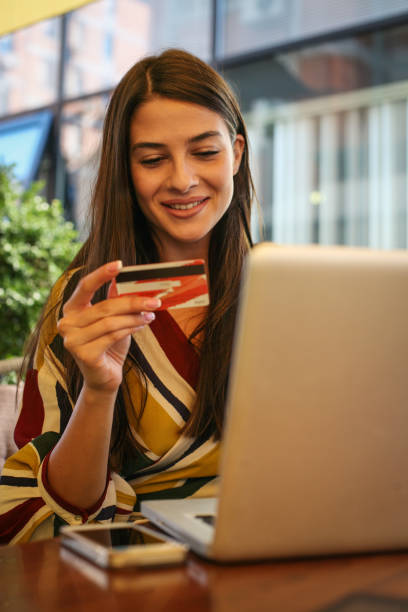 istock Young woman using lap top and credit card. 855832914