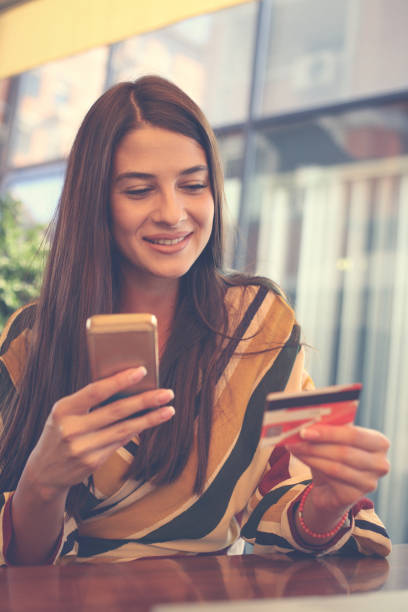 istock Young woman using smart phone and credit card. 855833232