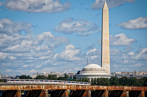 A train passing by the Washington and Jefferson Memorials on the Charles R. Fenwick bridge.