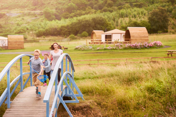 yurt camping holiday family young family walking across a bridge from their holiday accommodation yurt photos stock pictures, royalty-free photos & images