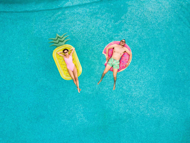 istock Couple relaxing at swimming pool 855839650
