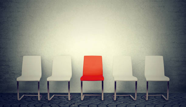 une ouverture pour le concept d’affaires emploi. rangée de chaises blanches et une rouge au milieu - empty seat photos et images de collection