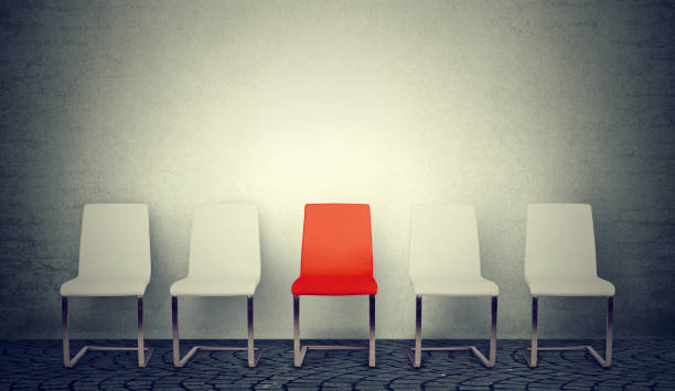 uma abertura para o conceito de negócio de emprego. linha de cadeiras brancas e uma vermelha no meio - employ - fotografias e filmes do acervo