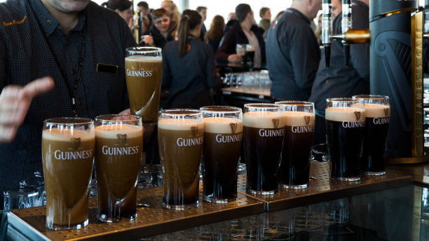 Guinness pints DUBLIN, IRELAND - FEB 15, 2014: Pints of beer are served at the Guinness Brewery. The brewery where 2.5 million pints of stout are brewed daily was founded by Arthur Guinness in 1759. guinness photos stock pictures, royalty-free photos & images