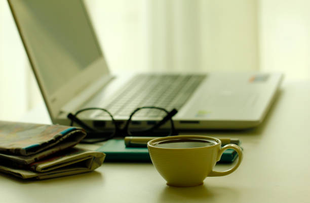 istock Stock Photo - Coffee, newspapers and laptop in soft focus setting with dramatic ambient light 855845700