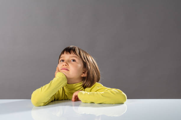smiling imaginative little child looking away, thinking and daydreaming for concept of kid curiosity, freedom, intelligence, future and open-mindness to protect, copy space