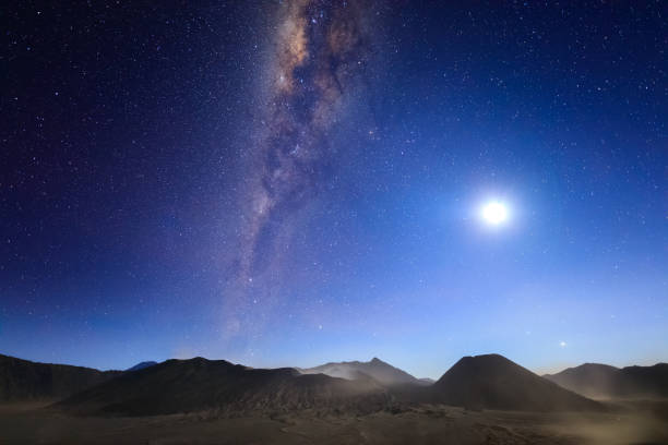 istock Bromo volcano with milky way, the moon and sand strom Tengger Semeru national park, East Java, Indonesia 855848474