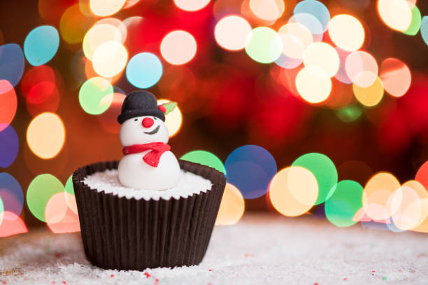 istock Christmas cupcakes with snowman and Christmas lights 855852436