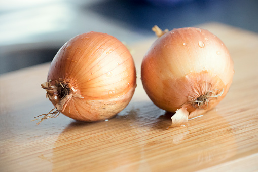 two wet onions on the cutting board