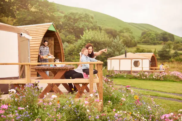 young family sit outside their yurt tent in wales