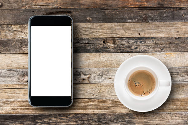 istock Flat lay Smartphone with blank white screen and coffee cup on wooden table background 855864420