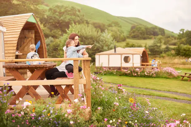 mother and daughter sit outside their yurt tent in wales