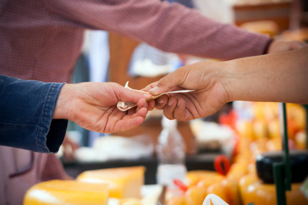 Payment hand to hand Paying with Euros on a cheese market square in The Netherlands cheese market stock pictures, royalty-free photos & images