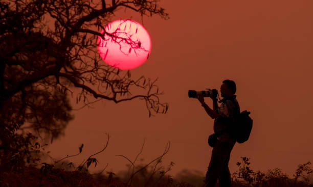 istock Silhouette man take photo on sunset 855876112