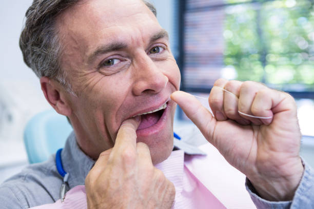 istock Portrait of man cleaning teeth with string 855880156