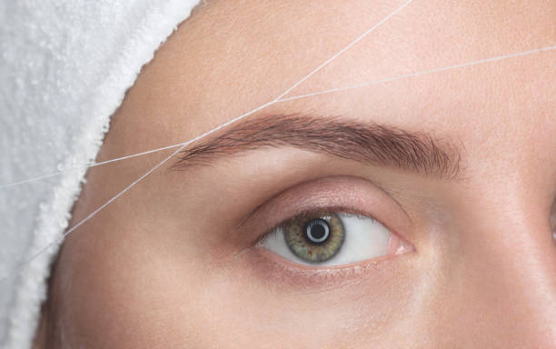 istock The make-up artist plucks her eyebrows with a thread close-up. 855880354