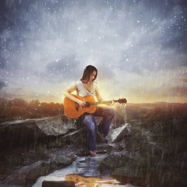 A hippie girl with her guitar singing in the middle of nature