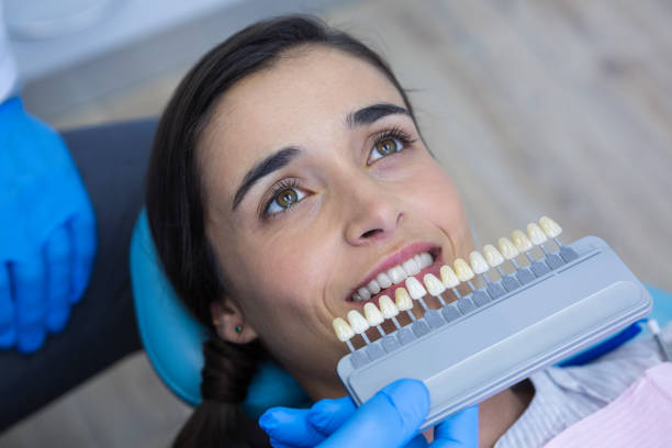 istock Dentist holding medical equipment while examining woman 855899568