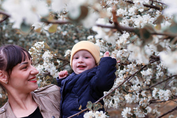 istock Mother with baby in summer garden sunny day forest tree 855906062