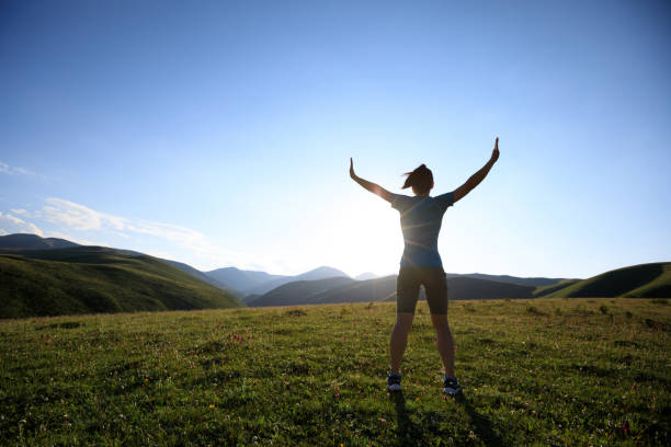 istock cheering woman open arms to sunset at mountain top 855907264