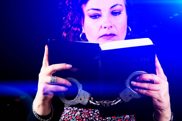 istock Woman reads the Bible holding hadcuffs 855909908
