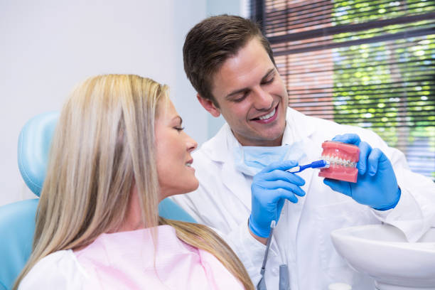 istock Dentist showing dental mold to patient 855914432