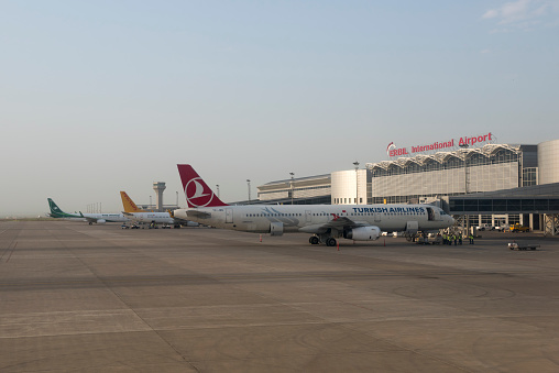 Erbil, Iraq - April 30, 2017: Three commercial aircraft belonging to Turkish Airlines, Pegasus Airlines, and Iraqi Airways are parked at gates at Erbil International Airport in Erbil, Iraq.