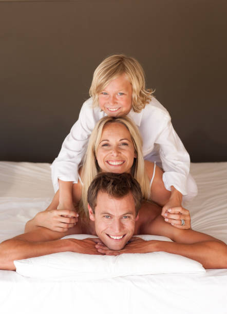 istock Happy family having fun together lying on bed 855918704