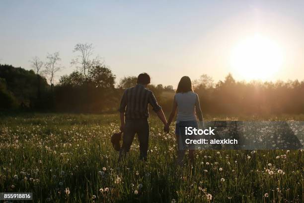 Pareja De Jóvenes Caminando En La Puesta De Sol De Primavera Por La Noche  En Un Foto de stock y más banco de imágenes de Adulto - iStock