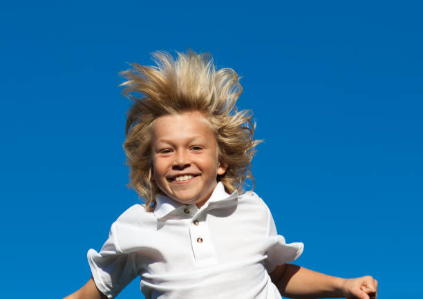 istock Young Kid Jumping in the air outdoor 855918890