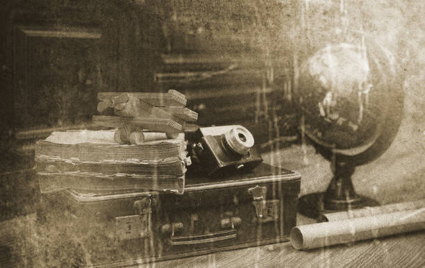 composition on a wooden floor vintage globe with old leather suitcase with objects for travel