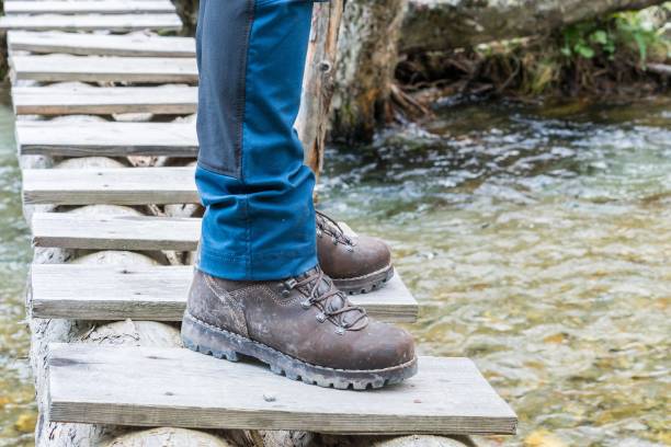 istock Hiking boots on tree trunk bridge over a creek 855931986