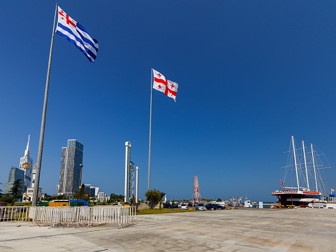 National flags of Georgia and Adjara against the blue sky. Georgia. Adjara.