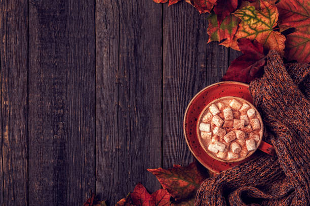 istock Autumn background with hot chocolate, knitted scarf, multi-colored leaves. 855935304