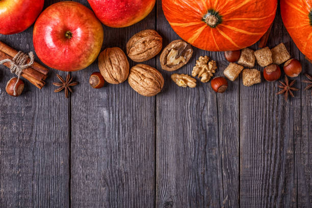 istock Wooden background with pumpkin, apples, nuts and spices. 855936084