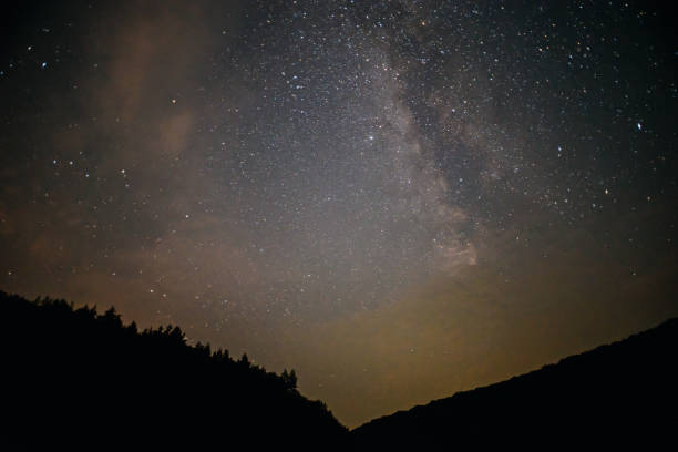 istock A clear night sky with a hill and trees in the foreground 855936568