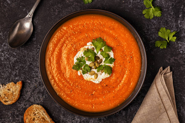 istock Pumpkin and carrot soup with cream, seeds and parsley. 855939902